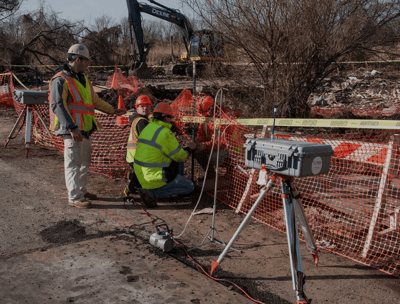 a man in a yellow vest and a camera on a tripod