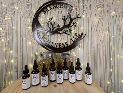 Branching Wellness logo with several tinctures displayed in front of logo