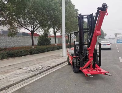 Our CC55 forklift crane attachment on a customer's red forklift. A practical forklift jib crane solution, shown outdoors.
