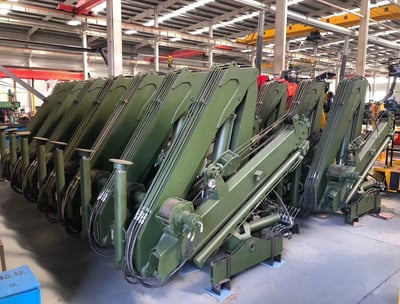 Customer order: Green SQZ68A.2 folding boom cranes at our truck-mounted crane manufacturing facility.