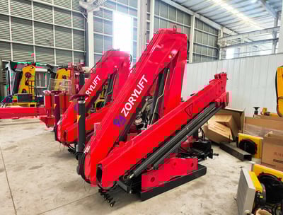 Factory floor: Black SQZ132A.3 knuckle boom cranes awaiting final assembly for customer order.