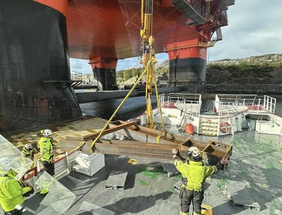 a group of men in yellow vests and safety vests working on a ship