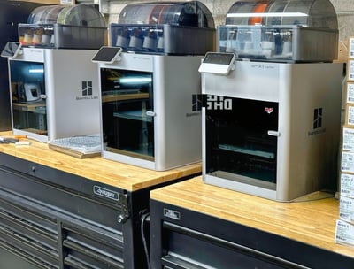 bunch of 3d printers on the bench