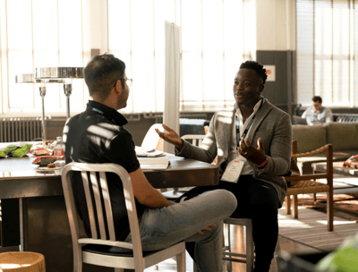two men sitting at a table with a table with a table cloth