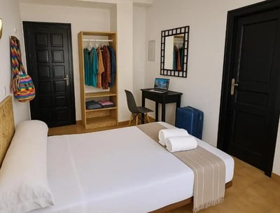 Habitación estándar del Hotel San Vicente en Conil, con cama doble, escritorio con portátil, armario