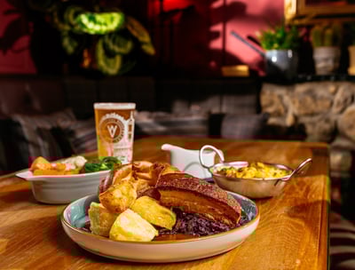 Roast dinner on a table in the snug area with a pint of beer