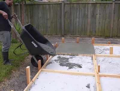 Pouring concrete manually in a concrete patio