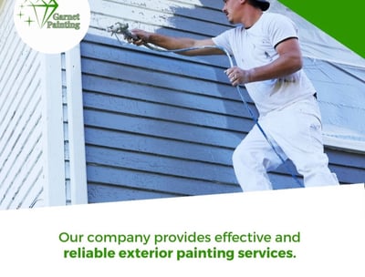 Garnet Painting team working on exterior house painting with company logo visible”