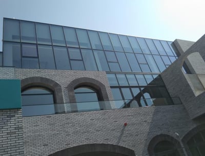 a building with a clock towering over a brick wall
