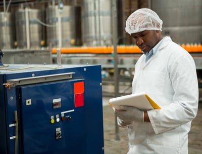 a man in a lab coat maintaining a machine