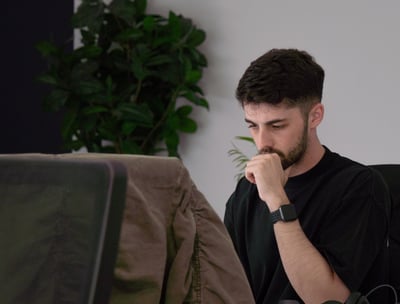 a man sitting at a desk with a laptop computer