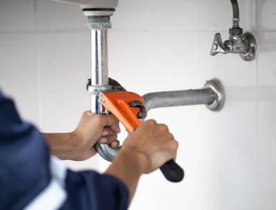 o imagine cu un instalator strangand de o teava