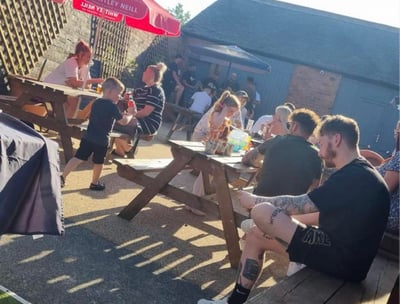 a group of people sitting in a beer garden