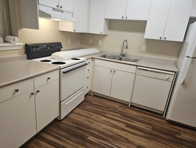a clean kitchen with white cabinets and white appliances