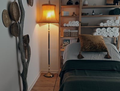 a massagebed with a golden pillow on top of a bed