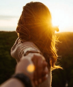 pareja en un campo agarrados de la mano felices despues de un amarre de amor efectivo