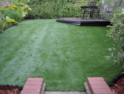 a backyard with a lawn and a deck