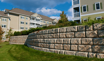 a wall of stone with a clock tower in the background