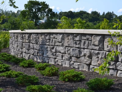 a stone wall with a stone wall and a bench