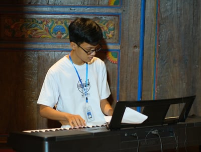 Tutor Kursus Musik Privat dari Notasi Music Course sedang Memainkan Piano