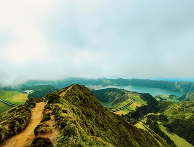 a person walking up a mountain with a view of a lake