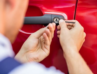 a man is fixing a keychaik on a red car