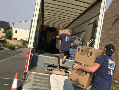 a man and woman loading boxes into a truck