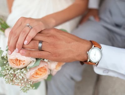 a just married couple holding their hands on a bouquet