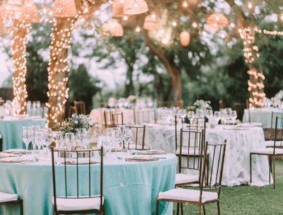 An outdoor wedding venue with light blue table cloths