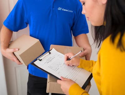 a man and woman holding boxes and a clipboard