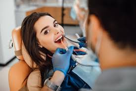 a woman in a dentist's chair with a dentist's hand