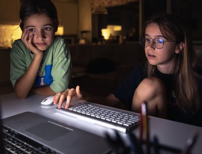 two young girls sitting at a computer desk