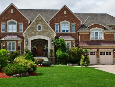 Stately red and tan brick house with lush landscaping in Tennessee 