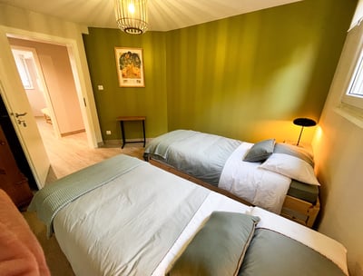 a bedroom with two beds and a lamp