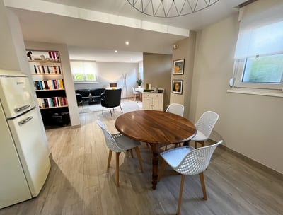 a dining room table with chairs and a refrigerator