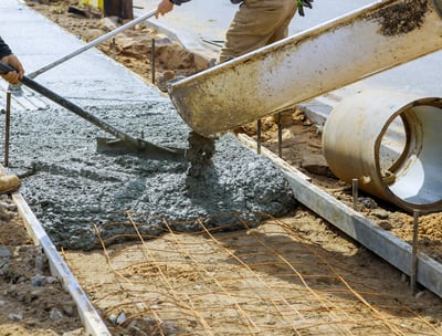 a man is pouring concrete into a concrete slab