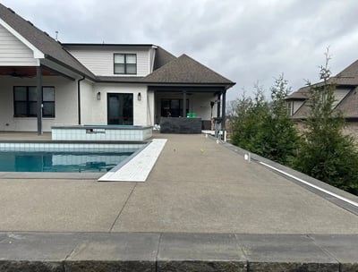 a pool with a concrete pool and a concrete patio