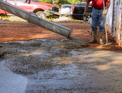 a man is pouring cement into a concrete wall