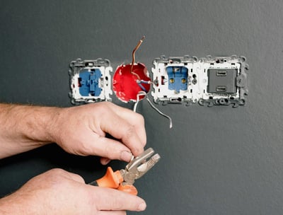 électricien installant une prise murale électrique