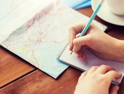a person holding a pen and writing on a notebook