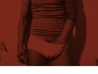 Toronto Gay Escort & Nude Male Massage by Nick Rivera | A red filtered photo of Nick in white briefs