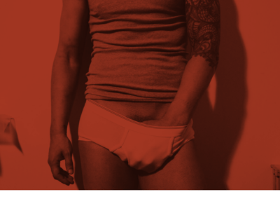 Toronto Gay Escort & Nude Male Massage by Nick Rivera | A red filtered photo of Nick in white briefs