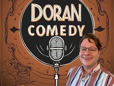a man in a striped shirt and glasses with a microphone