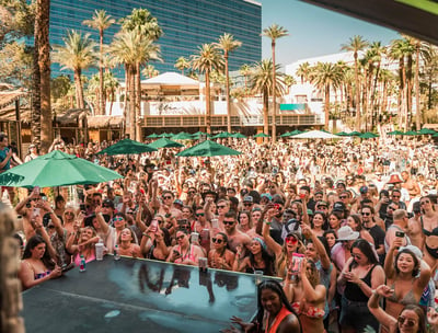 Crowd enjoying an open-bar party bus dayclub tour in Las Vegas with drinks and poolside fun.