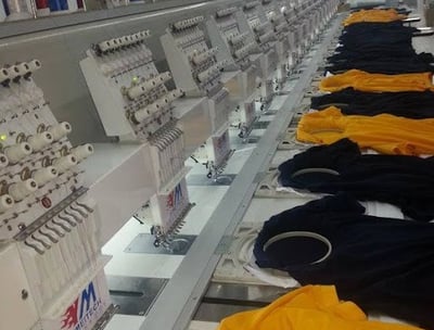 Technician operating embroidery machines for custom tactical patches at Zestlet.