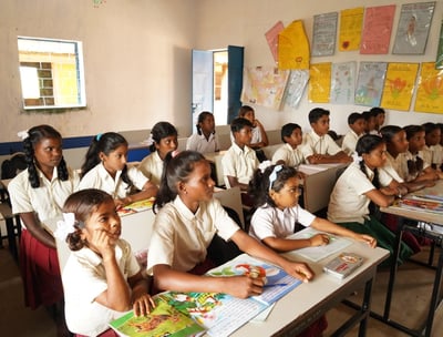 a group of children sitting at desks in a classroom