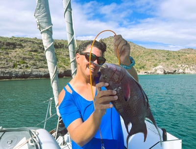 a woman holding a fish on a boat
