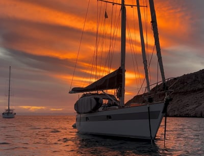 a sailboat in the water at sunset