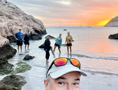 a man in a hat and hi friends on a beach