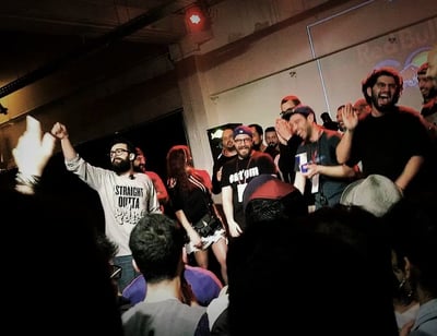 a man standing in front of a crowd of people in rap battle in the middle east